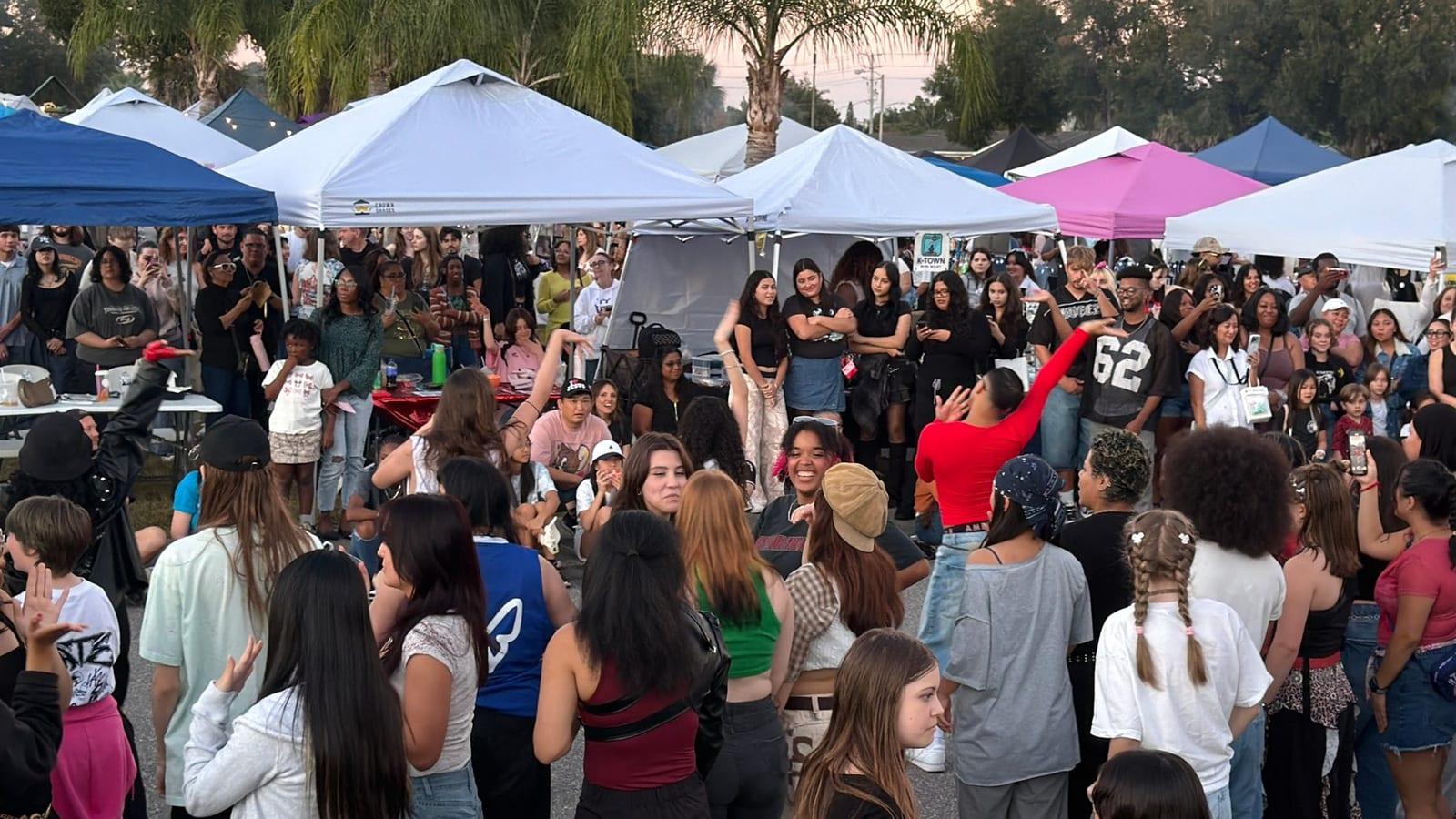 A dancer mid-move in the Random Dance Play circle, the crowd cheering around him